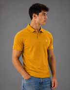 Man wearing a mustard yellow polo shirt with a logo on a gray background