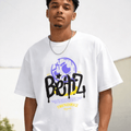 Person wearing a white t-shirt with a graphic design on a plain background