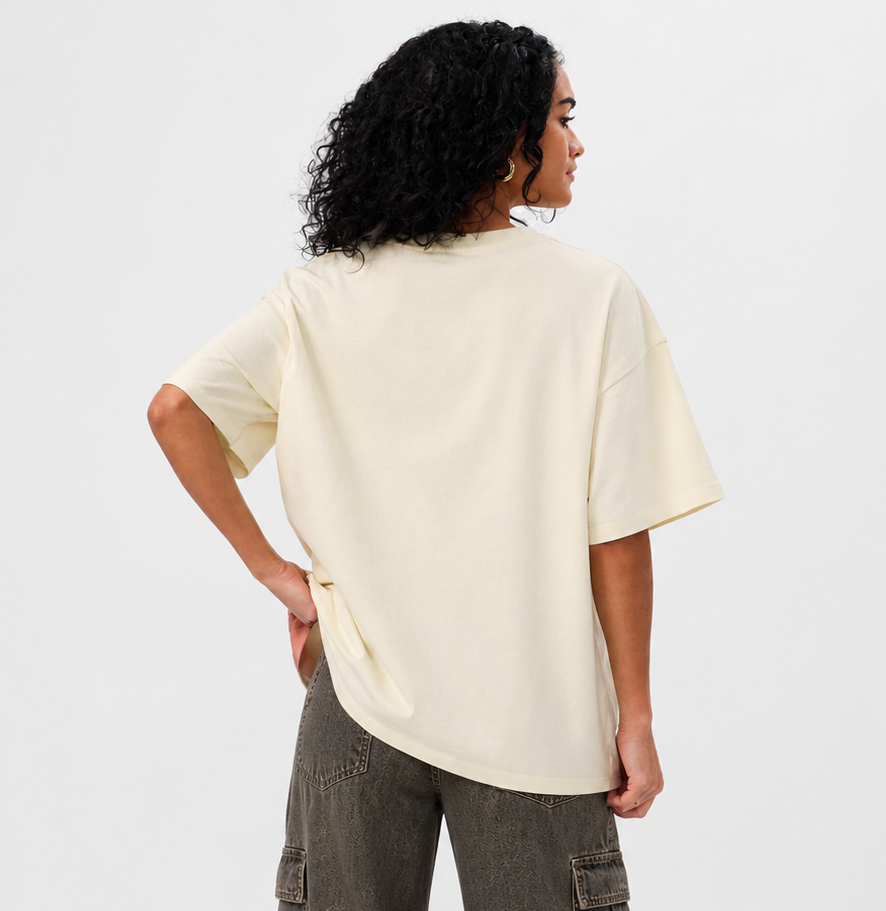 Person wearing a beige oversized t-shirt and cargo pants on a white background