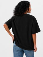 Person wearing a black t-shirt and blue jeans on a white background