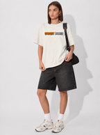 Person wearing a white t-shirt with text and black shorts on a white background