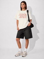 Person wearing a white t-shirt with text and black shorts on a white background