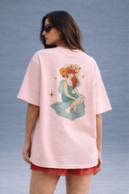 Woman wearing a pink t-shirt with a graphic design on a gray background