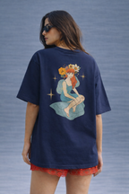 Woman wearing a navy blue t-shirt with a colorful graphic design on a gray background