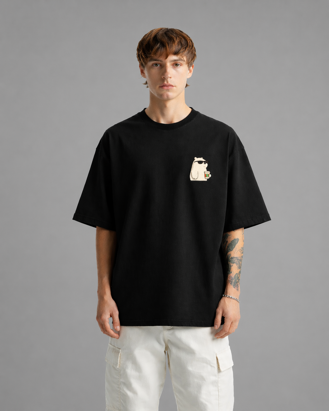 Person wearing a black t-shirt with a graphic design on a gray background