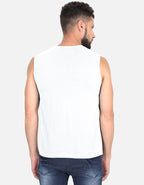 Man wearing a white sleeveless shirt and blue jeans on a light gray background