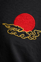 Embroidered red circle with gold waves on a black background