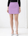 Person wearing a purple mini skirt with a white background