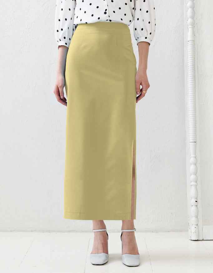 Person wearing a light green skirt with a white background