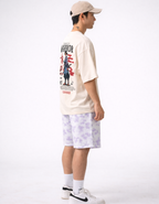 Person wearing a graphic t-shirt and patterned shorts on a white background