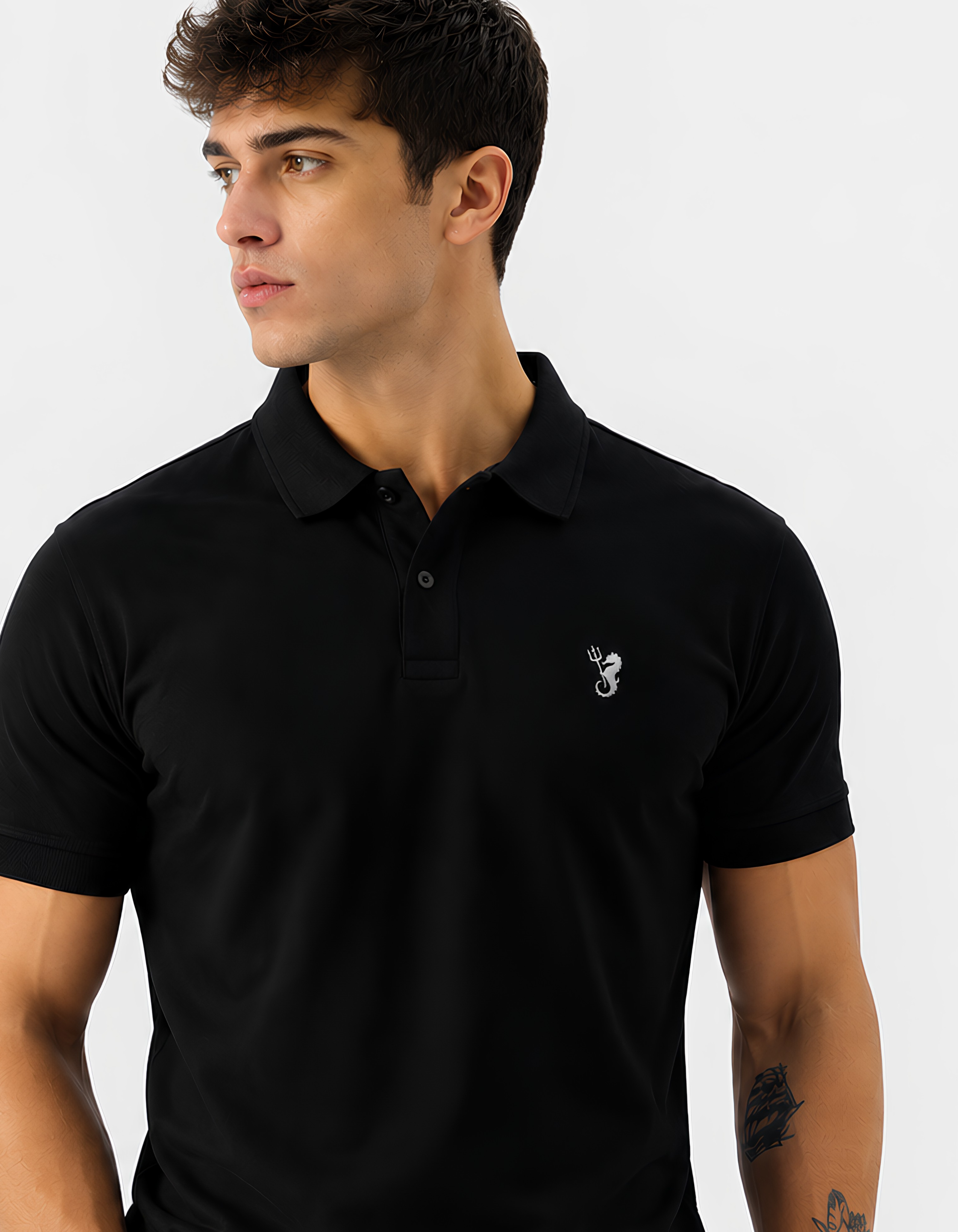 Man wearing a black polo shirt with a small logo on a light gray background