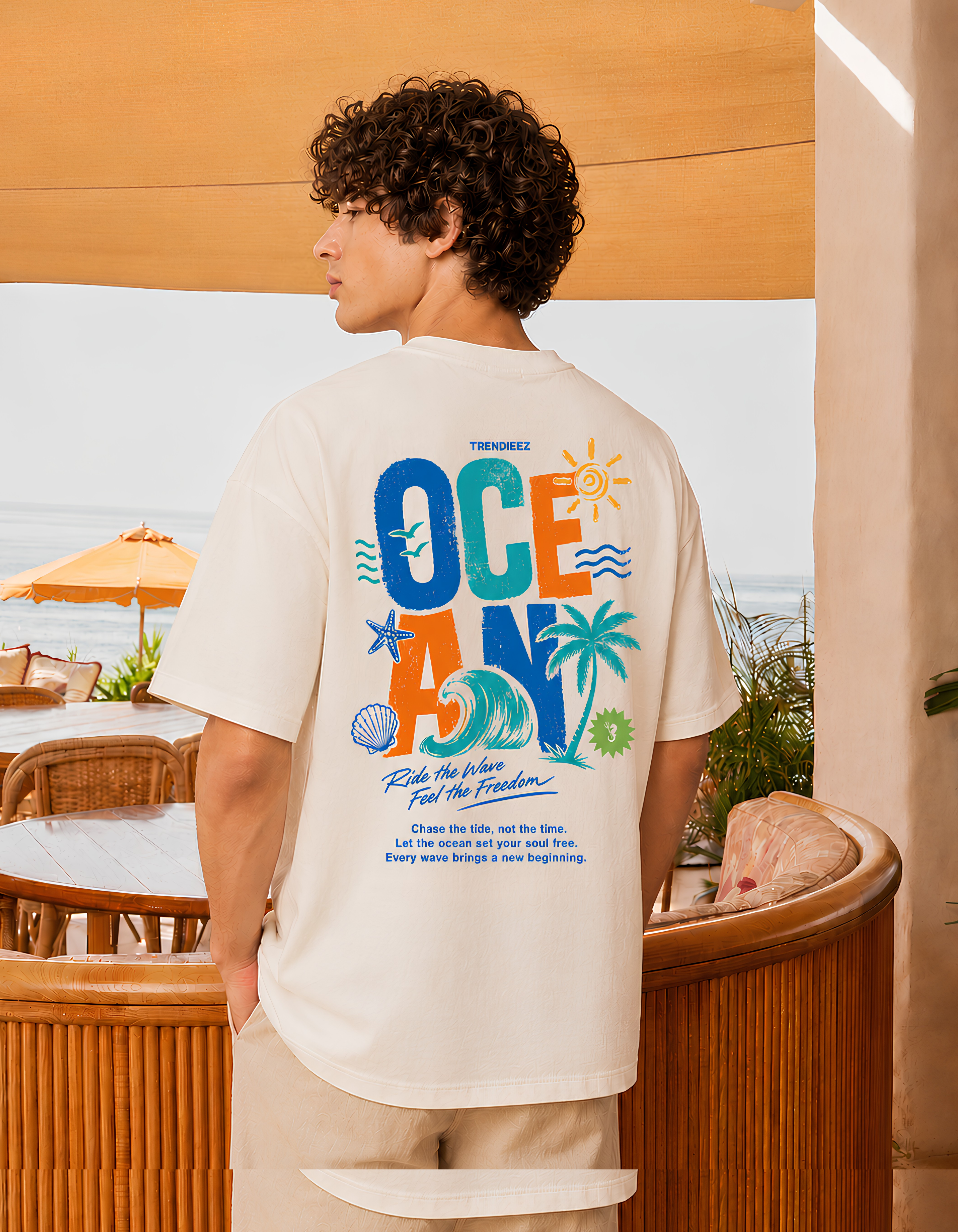 Person wearing a t-shirt with colorful graphics and text, standing in an outdoor setting.