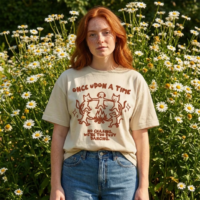 Person wearing a t-shirt with a graphic design in a field of flowers