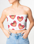 Person wearing a strapless top with heart and bear pattern on a plain background