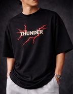 Person wearing a black t-shirt with 'THUNDER' logo on a dark background